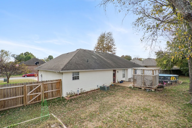 rear view of house featuring central AC unit, a patio area, and a lawn