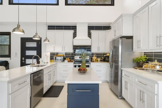 kitchen featuring stainless steel appliances, a kitchen island, white cabinetry, and sink