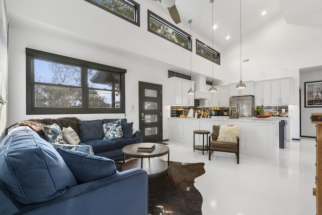 living room with a high ceiling and ceiling fan