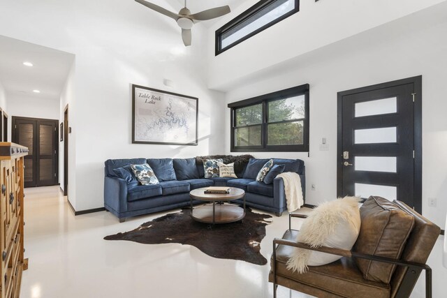 living room featuring ceiling fan and a towering ceiling