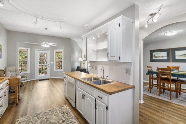 kitchen featuring wooden counters, white cabinetry, sink, and white dishwasher