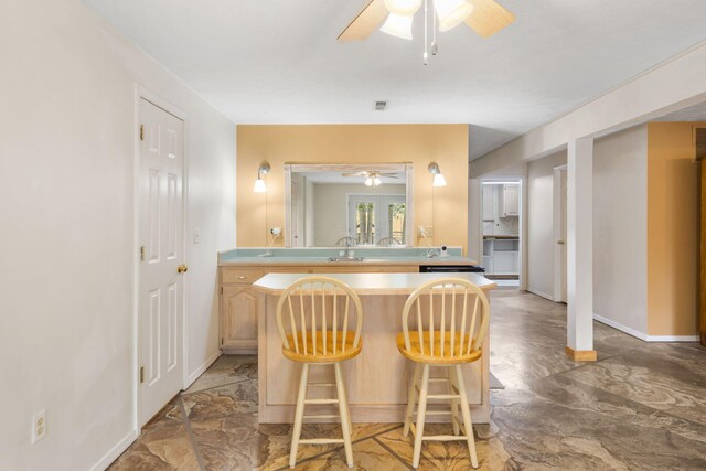 kitchen featuring a kitchen breakfast bar and ceiling fan