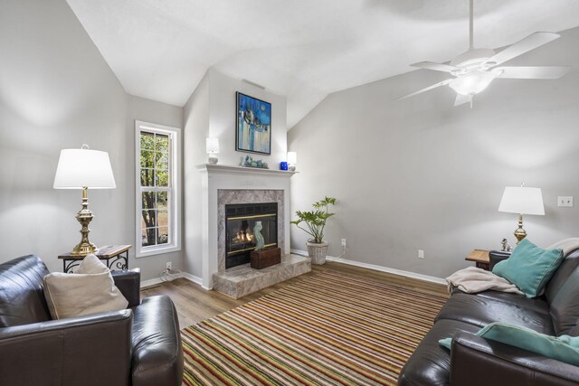 living room with ceiling fan, light wood-type flooring, and lofted ceiling