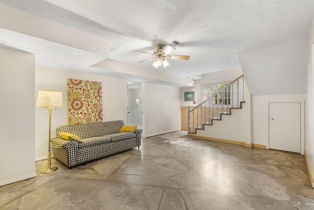 interior space featuring concrete flooring, ceiling fan, and a textured ceiling