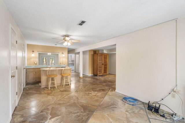 kitchen with ceiling fan and a breakfast bar area