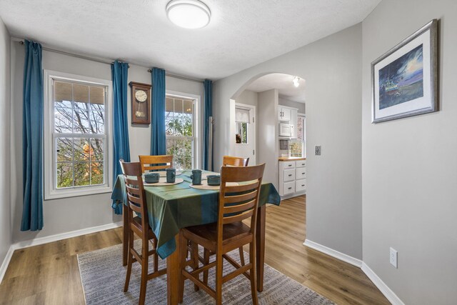 dining space featuring a textured ceiling and hardwood / wood-style flooring