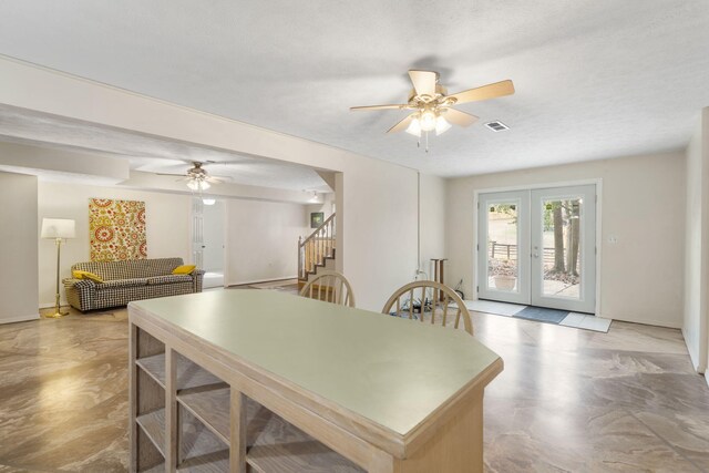 dining room with ceiling fan, a textured ceiling, and french doors