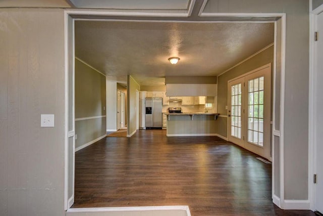 unfurnished living room with ornamental molding and dark hardwood / wood-style flooring