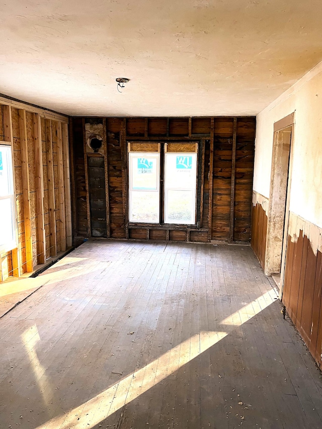 spare room featuring hardwood / wood-style floors and wooden walls