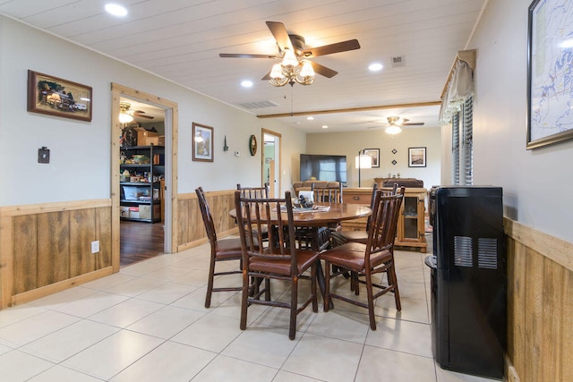 dining space with ceiling fan, wooden walls, wooden ceiling, and light tile patterned flooring