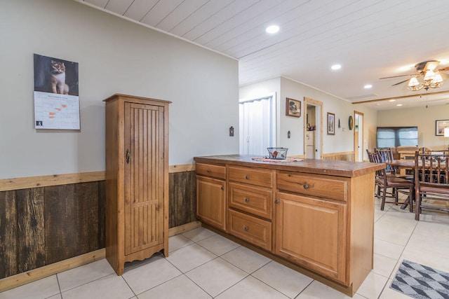 kitchen with kitchen peninsula, light tile patterned floors, ceiling fan, and wooden ceiling