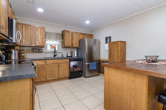 kitchen featuring sink, a kitchen bar, light tile patterned floors, and stainless steel appliances