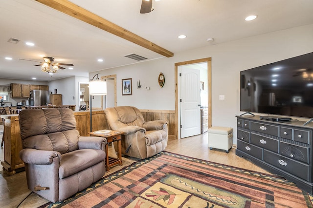 living room featuring light hardwood / wood-style flooring, wooden walls, beamed ceiling, and ceiling fan