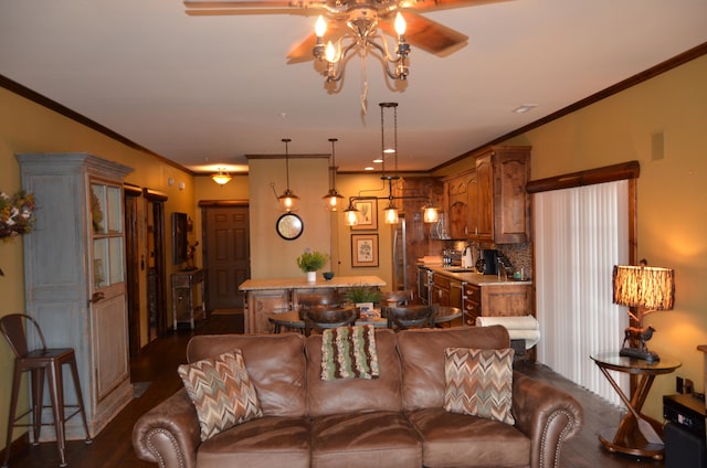 living room with dark wood-type flooring, ceiling fan, and crown molding