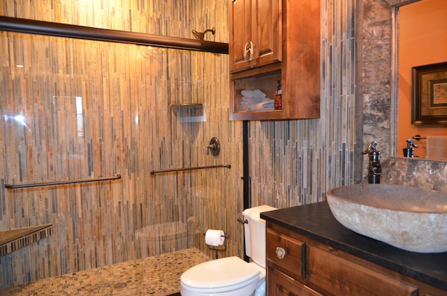 bathroom featuring a shower, vanity, toilet, and wooden walls