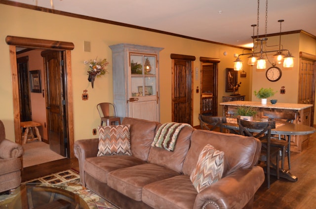 living room featuring dark hardwood / wood-style floors, a chandelier, and crown molding