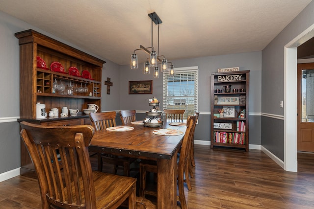 dining area featuring dark hardwood / wood-style floors and a textured ceiling