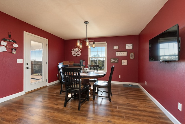 dining room featuring dark hardwood / wood-style floors and an inviting chandelier