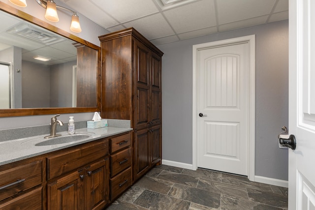 bathroom with a drop ceiling and vanity