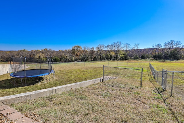 view of yard featuring a rural view and a trampoline