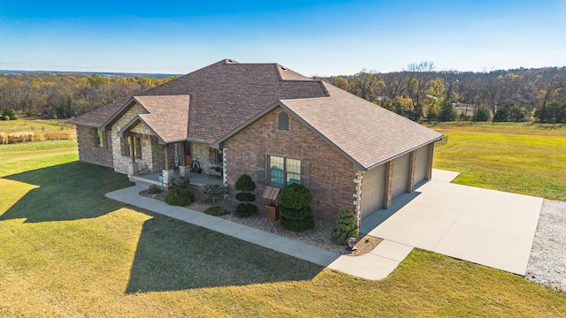 1558 E 432nd Rd, Bolivar, MO 65613 - view of front facade featuring a front lawn, concrete driveway, roof with shingles, covered porch, and brick siding