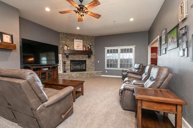 carpeted living room with ceiling fan and a fireplace