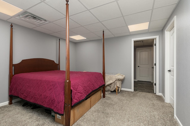 bedroom featuring light colored carpet and a drop ceiling