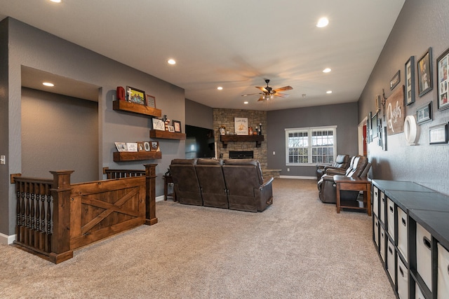 carpeted living room featuring a fireplace and ceiling fan