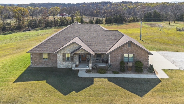 1558 E 432nd Rd, Bolivar, MO 65613 - view of front facade featuring covered porch, a front lawn, stone siding, and a view of trees