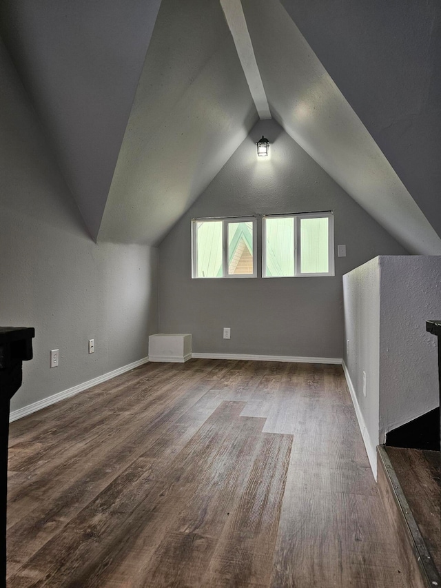 additional living space with dark wood-type flooring and lofted ceiling