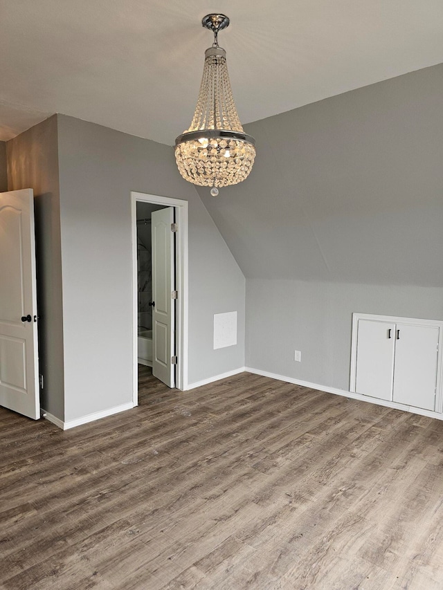 additional living space featuring wood-type flooring and vaulted ceiling