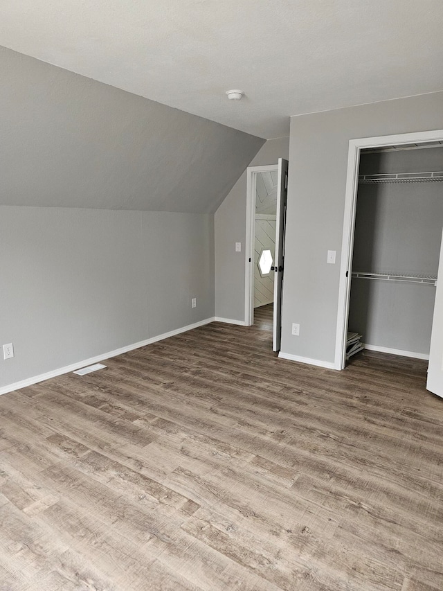 bonus room featuring lofted ceiling and hardwood / wood-style flooring