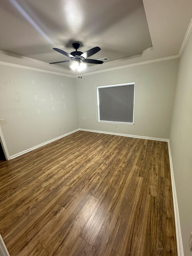 empty room with ceiling fan, wood-type flooring, and crown molding