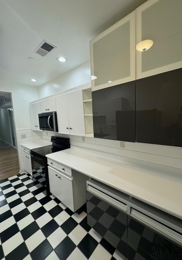 kitchen featuring white cabinetry and black electric range oven