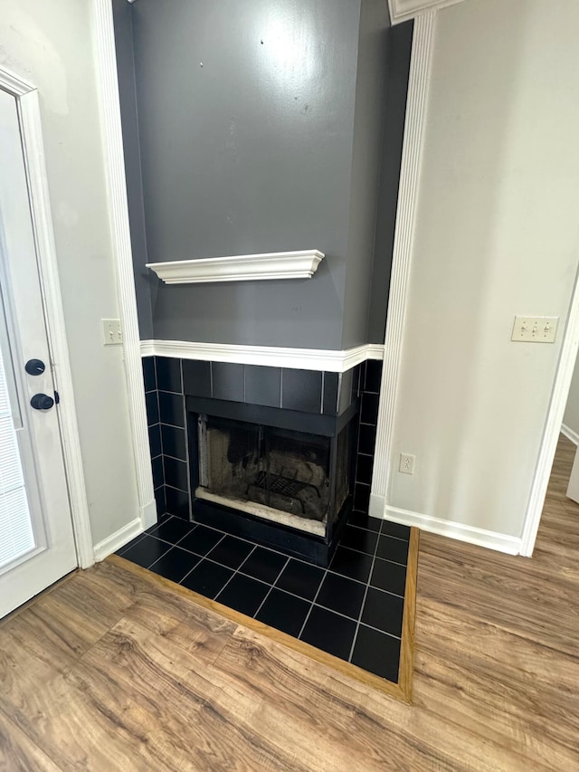 room details with a tiled fireplace and wood-type flooring