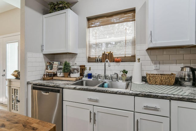 kitchen featuring dishwasher, white cabinets, sink, and backsplash