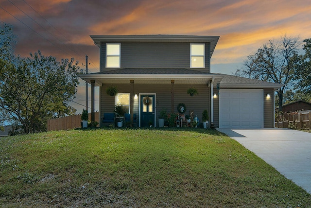 view of front of property with a garage, covered porch, and a yard