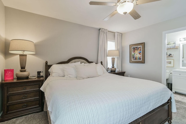 carpeted bedroom with ensuite bathroom and ceiling fan