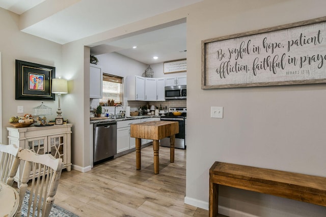 kitchen featuring white cabinetry, stainless steel appliances, light hardwood / wood-style floors, and sink