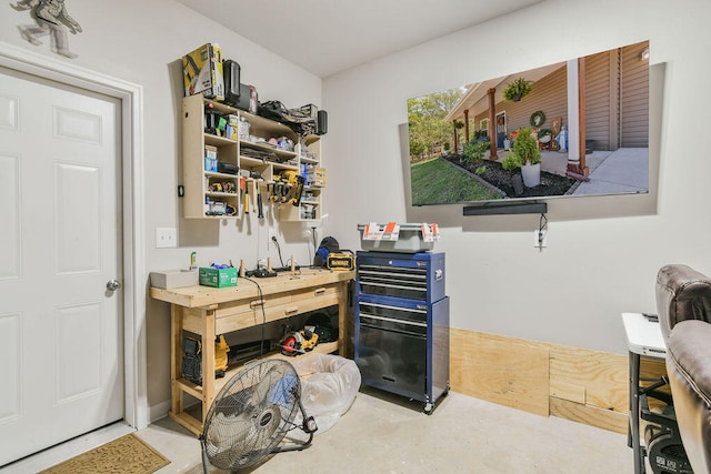 office with concrete flooring and a workshop area