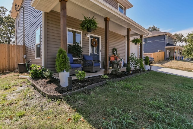 view of front of home featuring central AC unit, a front lawn, and covered porch