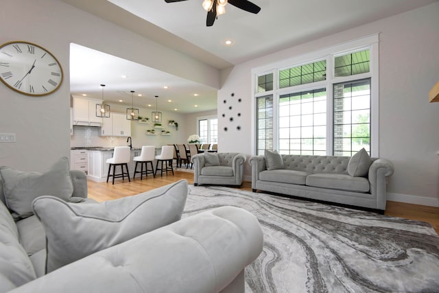 living room with light hardwood / wood-style floors and ceiling fan