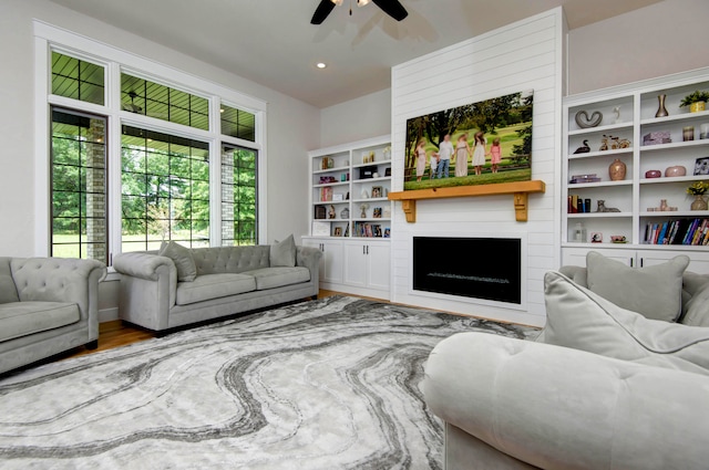 living room featuring a fireplace, hardwood / wood-style flooring, and ceiling fan