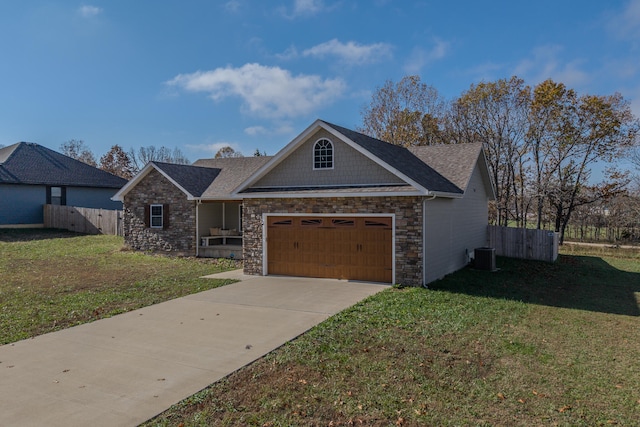 view of front of house with a garage, cooling unit, and a front lawn