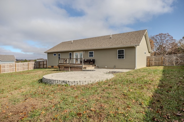 back of property with a wooden deck and a lawn