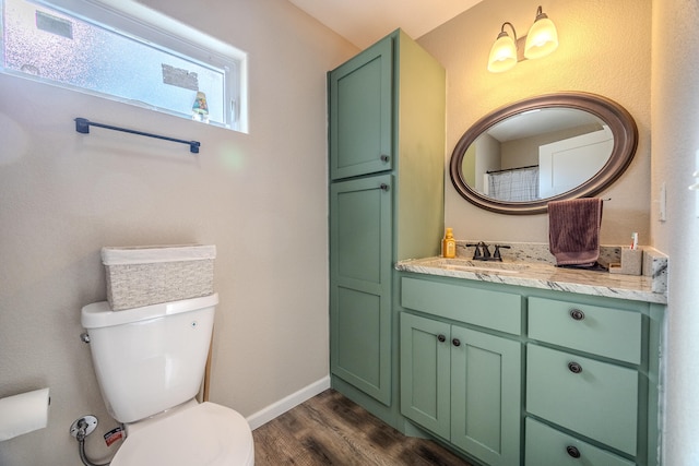 bathroom featuring toilet, vanity, and hardwood / wood-style flooring