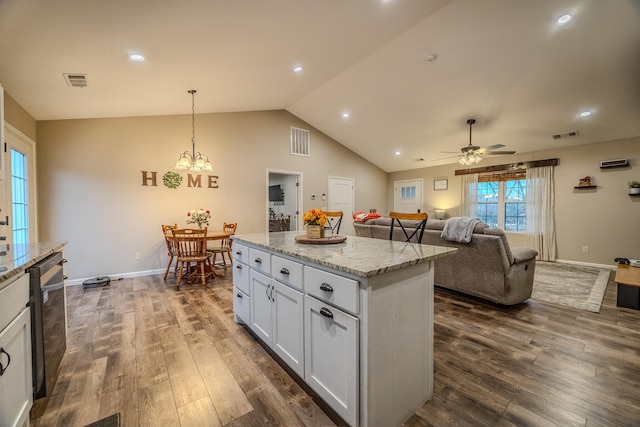 kitchen with dark hardwood / wood-style flooring, light stone countertops, hanging light fixtures, white cabinets, and lofted ceiling