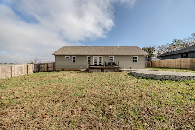 back of house featuring a lawn and a wooden deck