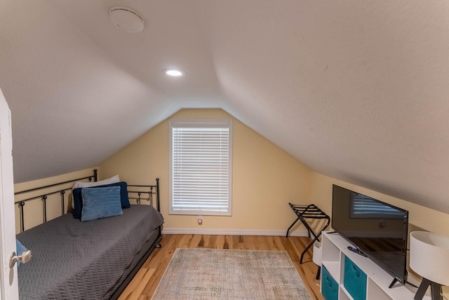 bedroom featuring hardwood / wood-style flooring and vaulted ceiling