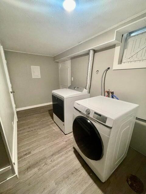 laundry area featuring washer and dryer and light hardwood / wood-style floors